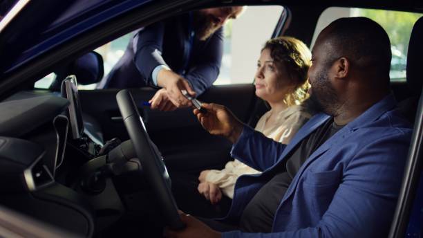 istock Clients going on test drive before buying car, receiving keys from salesman 2194985607