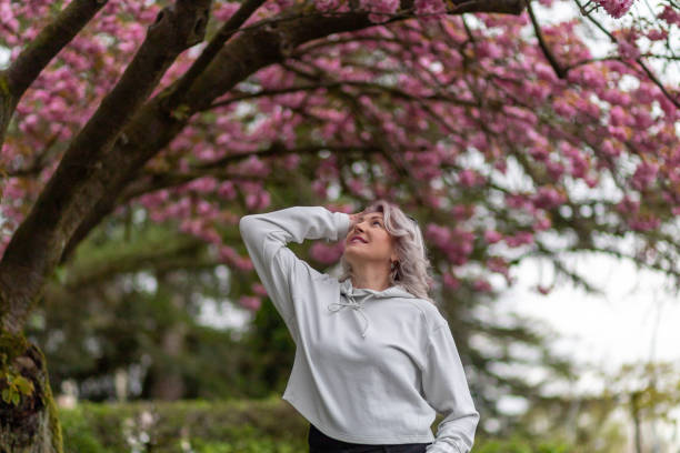 istock Woman enjoying a spring day under blooming cherry blossom trees in a park 2194985644
