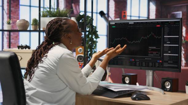 istock Frustrated day trader looking at PC screens showing falling stock prices 2194985806