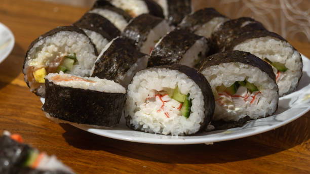 istock Sliced ​​sushi rolls on a white plate close-up 2194990005