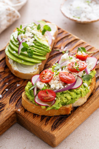 istock Fresh avocado toasts on wooden board 2194993514