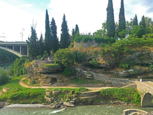 istock Park with stone pathways with a rocky hillside and a stone bridge 2194994422