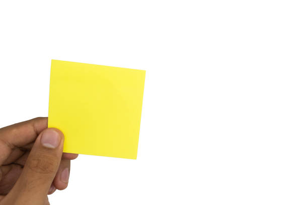 istock close up of male hand holding empty sticky note on white background 2195001369