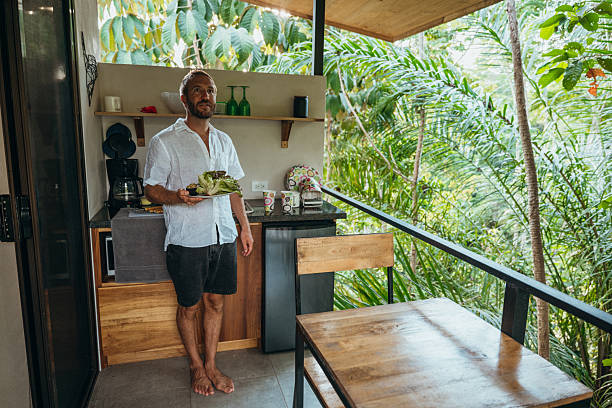 istock Man Enjoying Breakfast in Tropical Outdoor Kitchen 2195001796