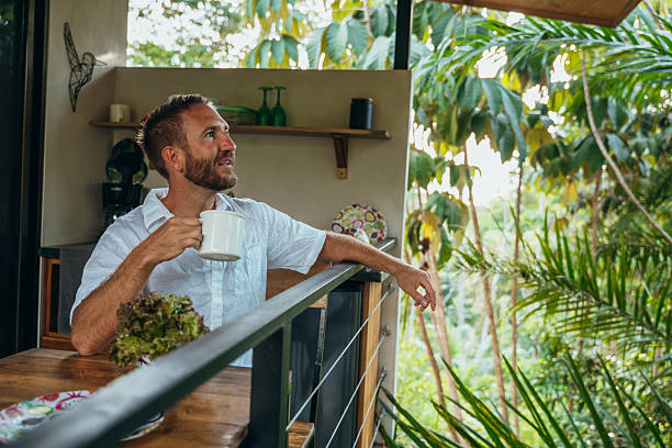 istock Man Enjoying Coffee on a Tropical Balcony with Scenic View 2195002056