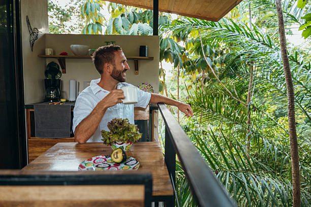 istock Man Enjoying Coffee on a Tropical Balcony with Scenic View 2195002057