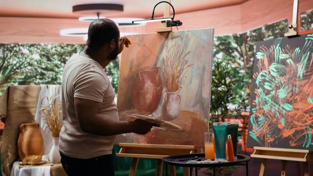 istock Painter applies watercolor paints on a canvas with a certain technique 2195007018