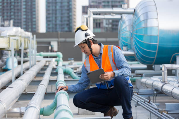istock Male engineer work using digital tablet for checks or maintenance in sewer pipes area at construction site. Male plumber working in sewer pipes area at rooftop of building 2195008415