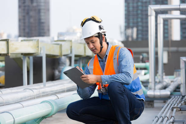 istock Male engineer work using digital tablet for checks or maintenance in sewer pipes area at construction site. Male plumber working in sewer pipes area at rooftop of building 2195008424