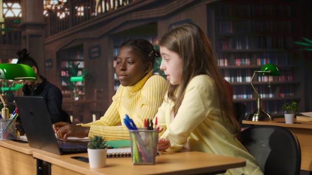 istock Primary school pupils in a library discuss during an online seminar 2195008606