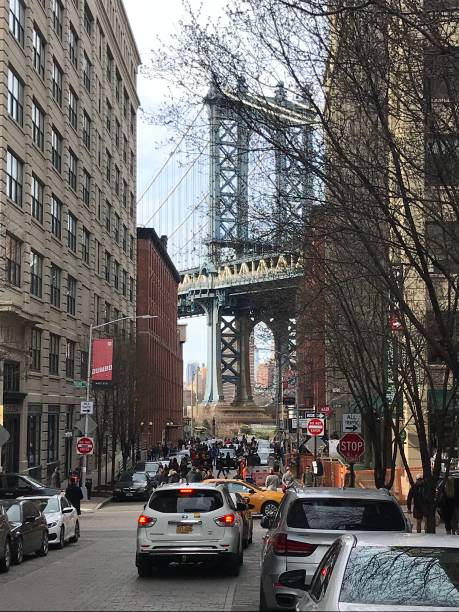 istock Crowd gathers under the Manhattan Bridge in Brooklyn on a cloudy day 2195011484