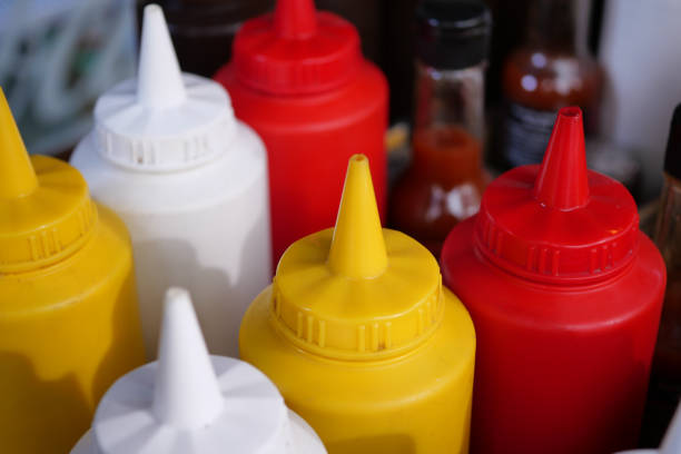 A vibrant and colorful assortment of various condiment bottles beautifully displayed on a table