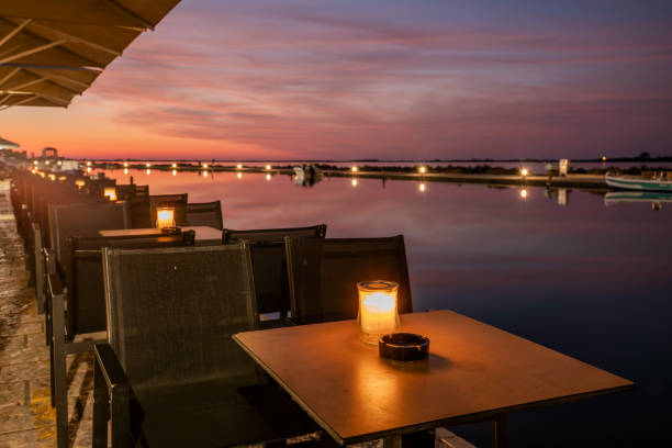 istock Rows of tables illuminated by candlelight in a lantern at a restaurant on the seaside boulevard 2195012648
