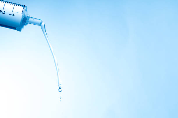 Water droplets falling from a syringe-shaped dropper
