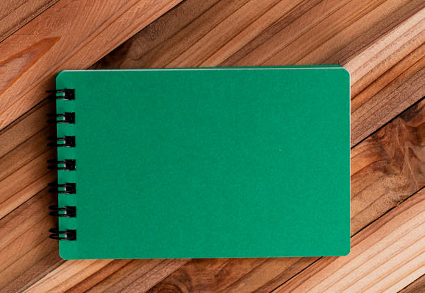 Green notepad on a wood background
