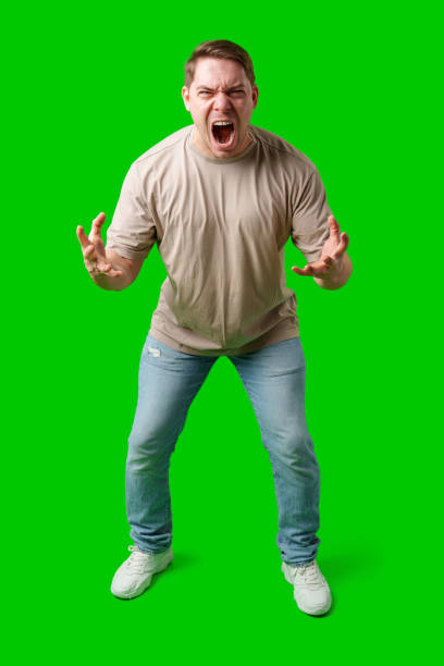 istock Man expressing intense frustration while standing against a bright green background 2195016840