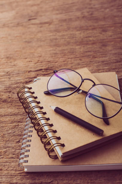 istock A notebook with glasses on it on wooden background 2195019292