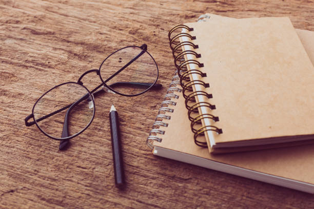 istock A notebook with glasses on it on wooden background 2195019294
