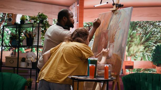 istock Team of skilled artists collaborating on rustic painting in art studio 2195021526