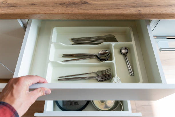 istock A person is carefully opening a drawer containing silverware inside it 2195025142