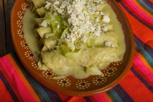 istock Green enchiladas with lettuce and cheese served in a clay dish. Close up 2195026004