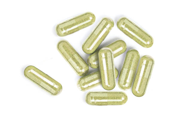 istock Green herbal powder medicine capsules 2195026259
