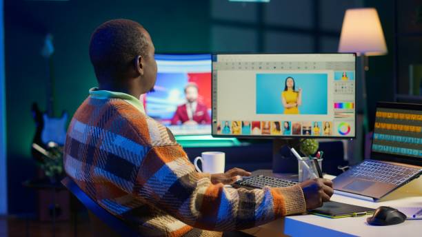 African american male photo editor multitasking on dual monitors in modern setup