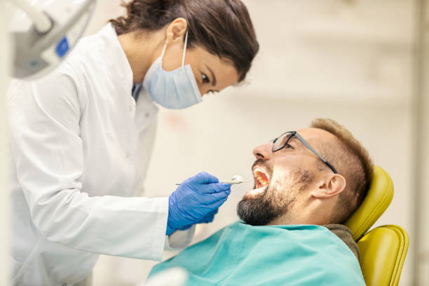 istock Patient sitting in chair at dentist office while dentist examining his teeth. 2195035585