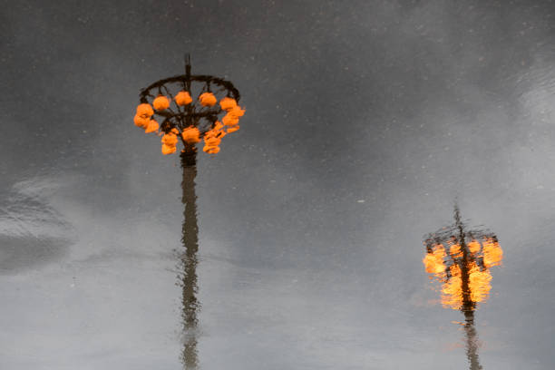 Lanterns are reflected in puddles on a rainy spring day