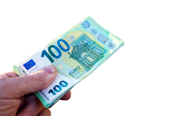 Man holding in hand 100 euro banknotes on white background. Hand giving bunch of 100 euro money isolated on white background. One hundred euro banknotes. Wad of money of European Union currency.
