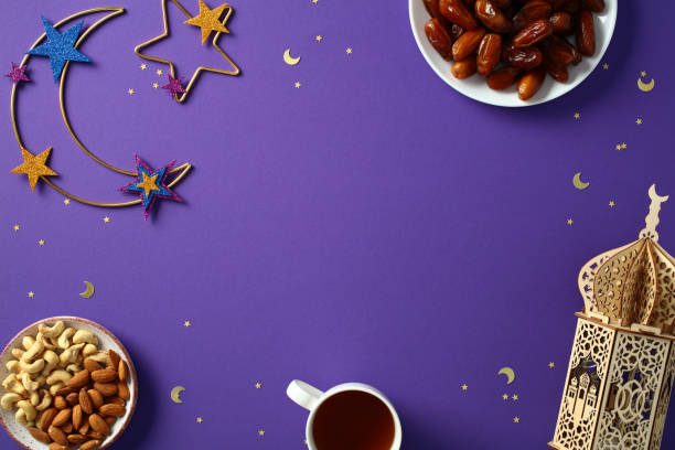 istock Ramadan flat lay composition. Top view crescent moon, decorative lantern, nuts, dates, and cup of tea on purple background. Ramadan Kareem and Eid Mubarak concept. 2195039904