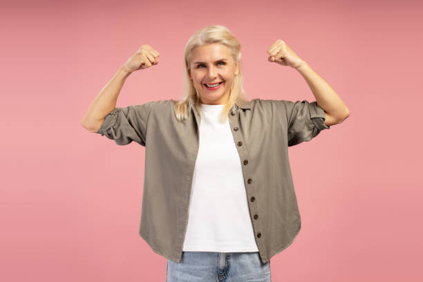 istock Strong confident woman flexing biceps on pink background 2195041127