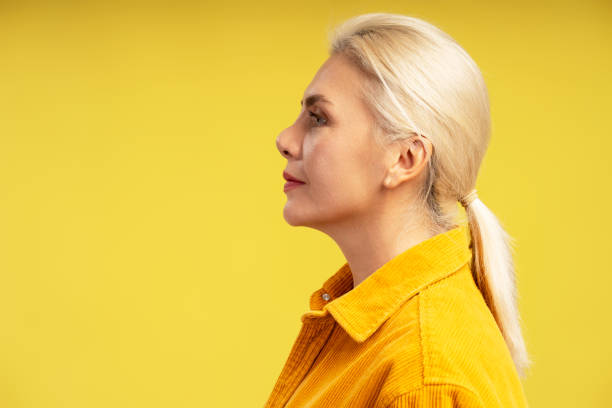 istock Blonde woman with ponytail posing on yellow background 2195041186