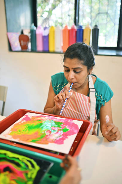 istock Woman crafting fluid art using a straw technique 2195041646