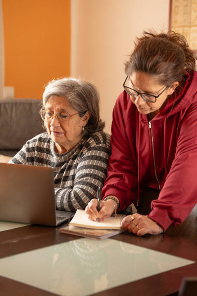 istock woman helps her mother with the computer 2195046132