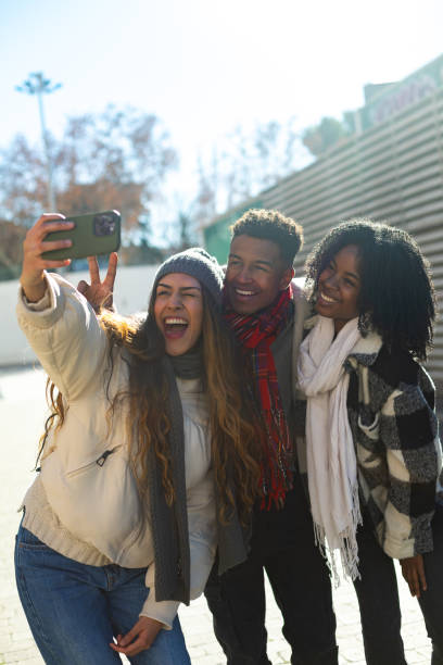 istock Three happy students taking a selfie outdoors in winter 2195046185