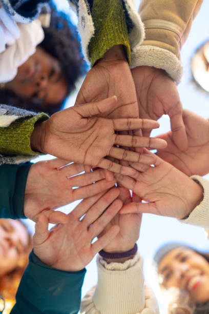 Students joining hands in a circle promoting teamwork and collaboration