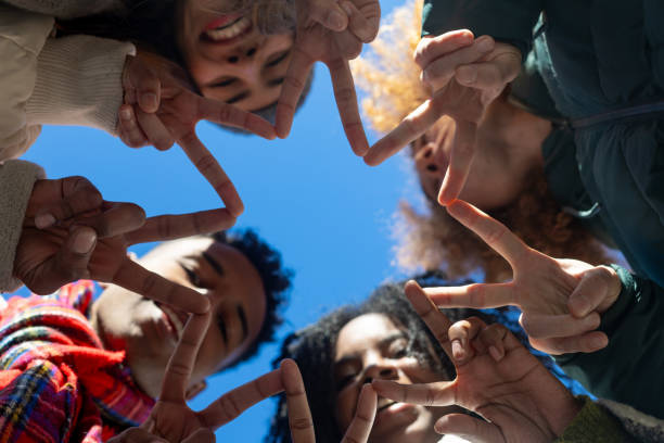 istock Group of diverse friends making star shape with fingers 2195046300