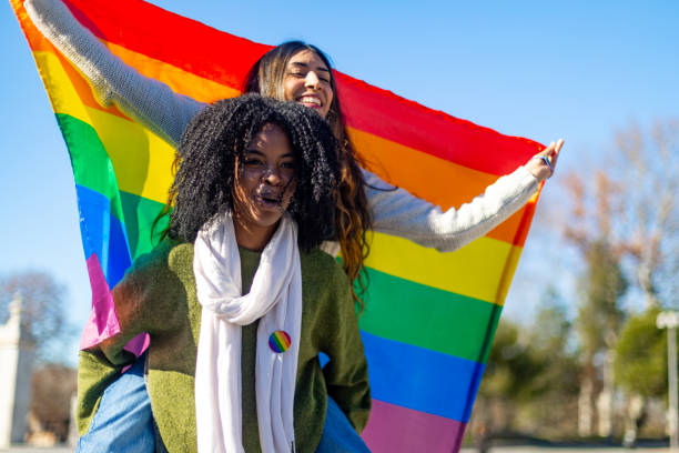 istock Two happy women holding rainbow flag celebrating lgbt pride 2195046355