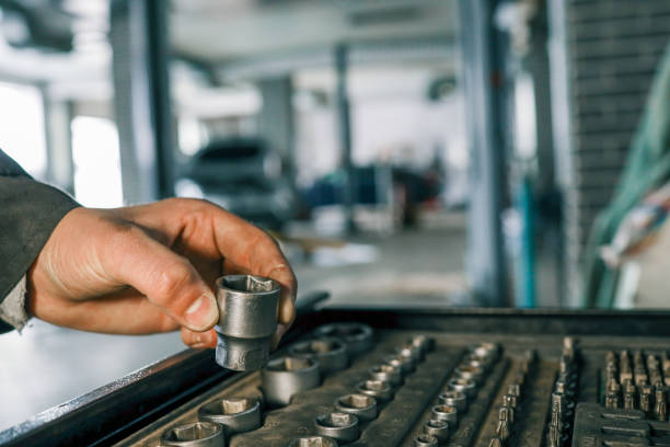 istock Hand selecting a metal socket wrench piece from an organized tool tray in a workshop setting, symbolizing precision and automotive repair 2195048359