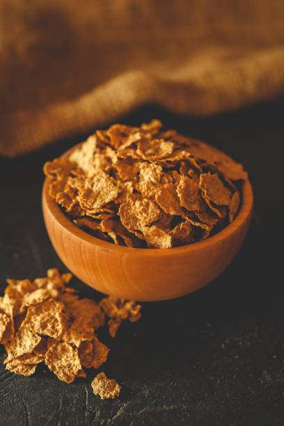 istock A wooden bowl filled with crunchy breakfast cereal flakes on a dark surface with rustic fabric in the background. Perfect for illustrating breakfast or healthy eating concepts 2195049092