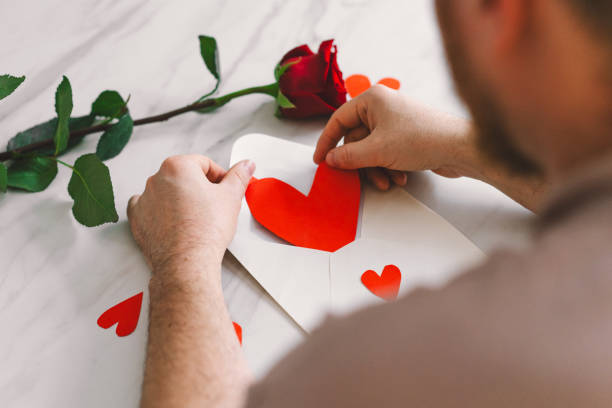 istock Happy Valentine's Day and romantic gesture. A man writes a valentine. 2195049093