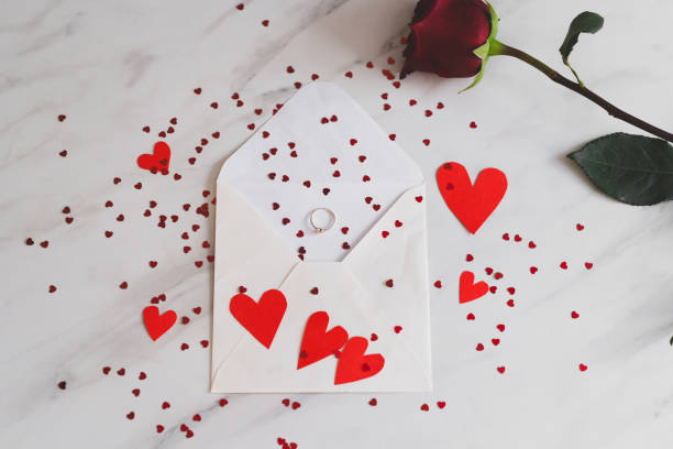 istock Heartfelt proposal on a handwritten note with a ring on a red paper heart 2195049347