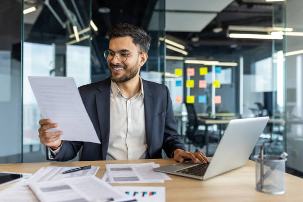 istock Latin American businessman working with documents and laptop in a modern office 2195050188