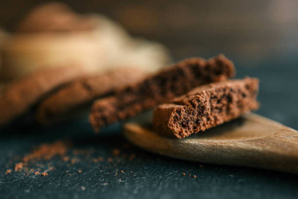 Chocolate brownie cookies on wooden spoon, sweets background.