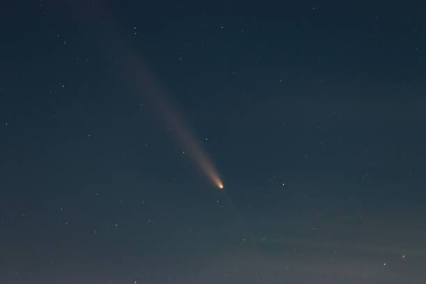 istock Clear night sky showcasing a bright comet with a visible tail among scattered stars. 2195056058