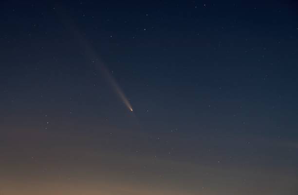 istock Clear night sky showcasing a bright comet with a visible tail among scattered stars. 2195056111