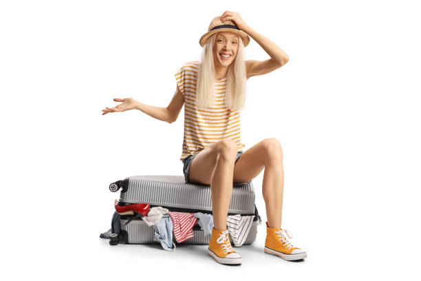istock Funny young woman sitting on an overpacked suitcase 2195056456