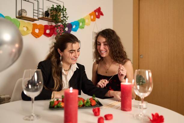 istock Lesbian couple celebrating valentine's day at home with romantic dinner 2195060138