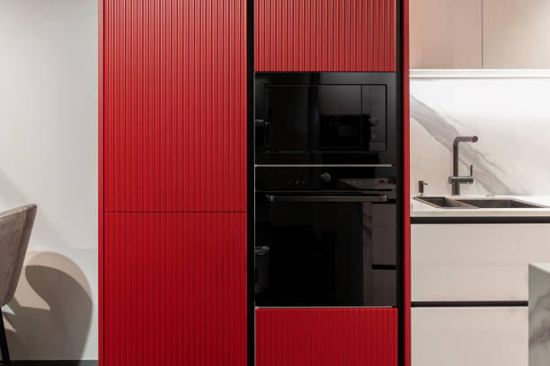 istock Built-in kitchen appliances: black microwave and oven in a red cabinet 2195062350
